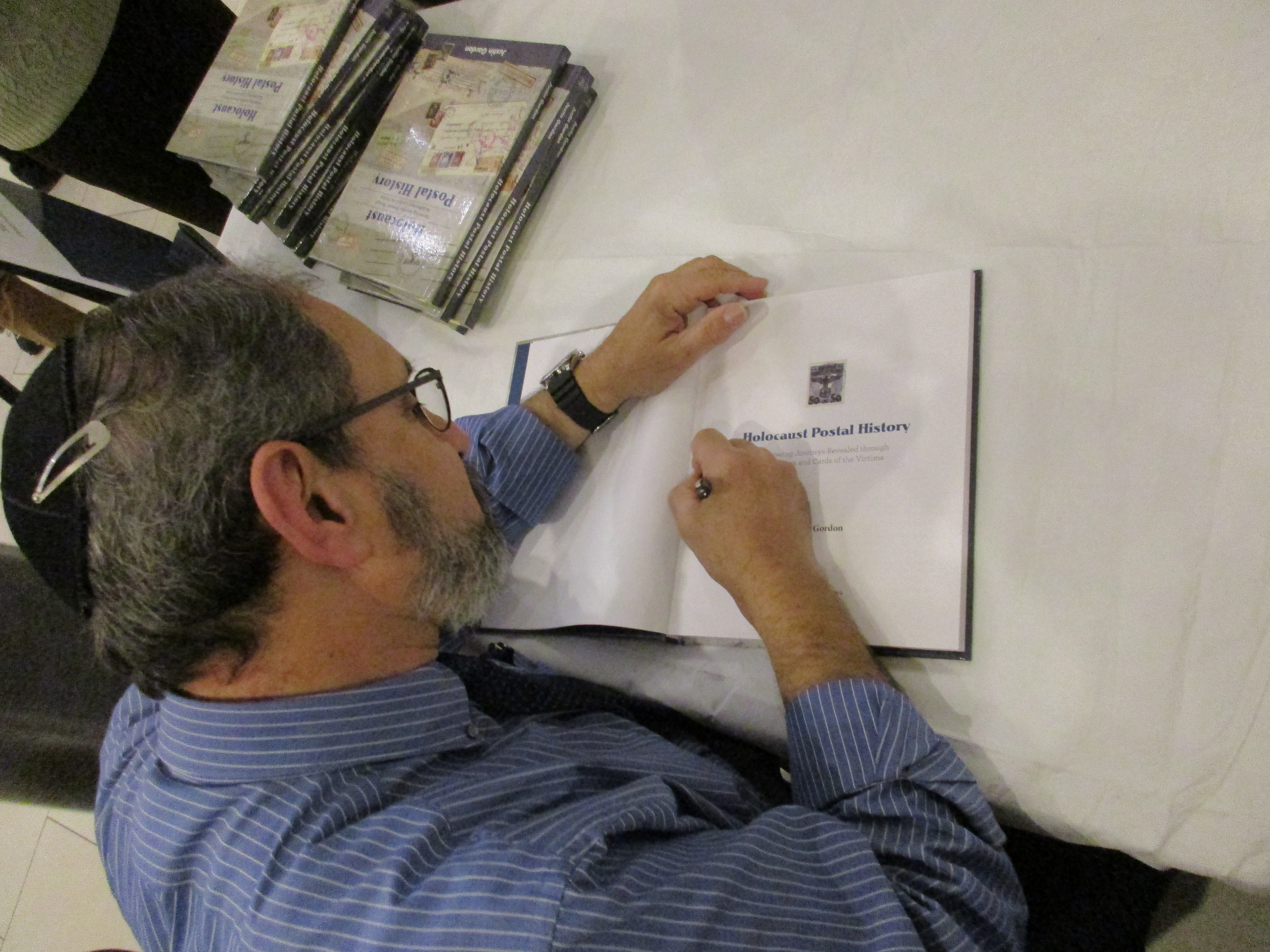 Author Justin Gordon signs a copy of Holocaust Postal History.