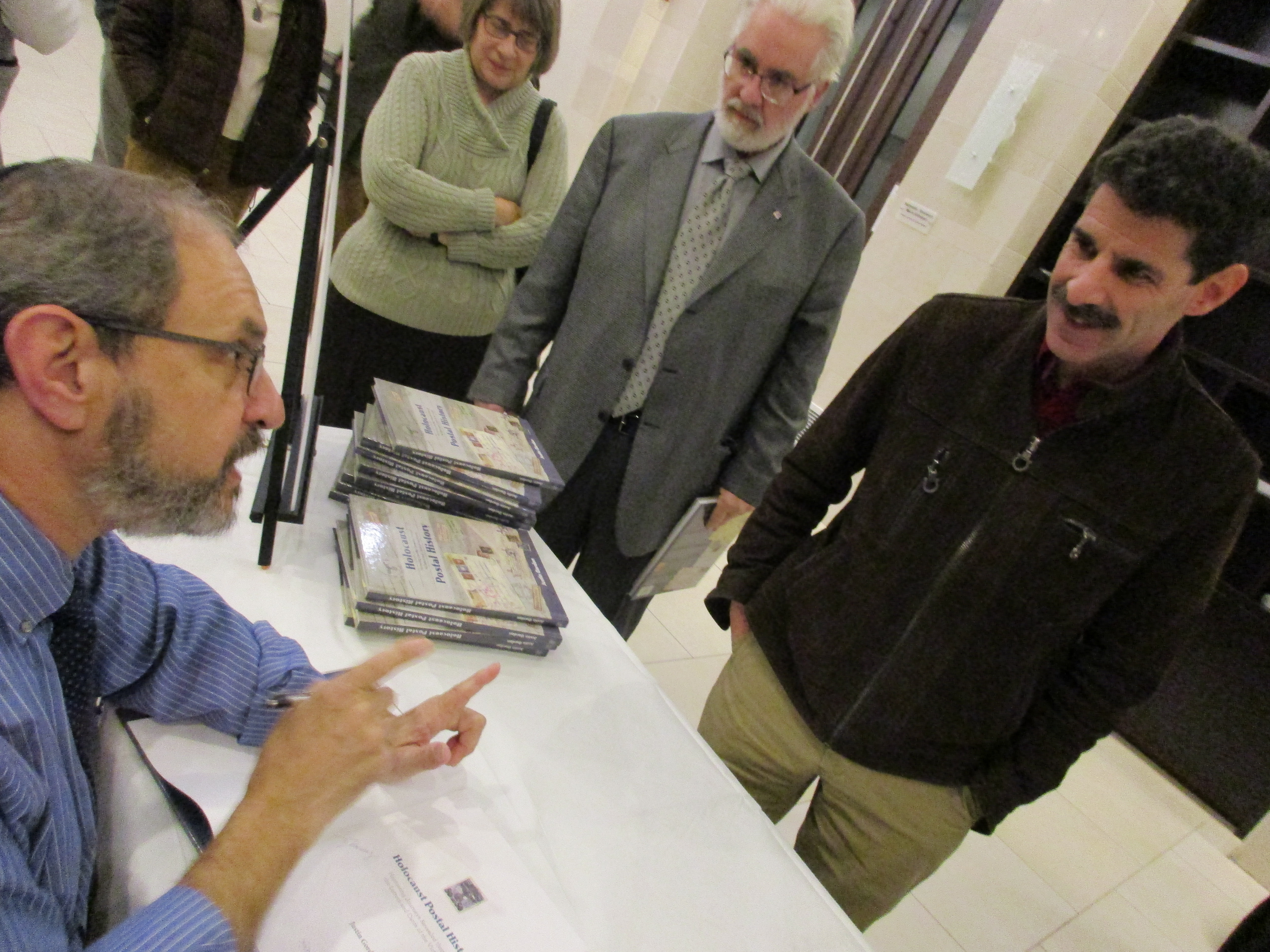 Author Justin Gordon discusses his book Holocaust Postal History with an attendee. 